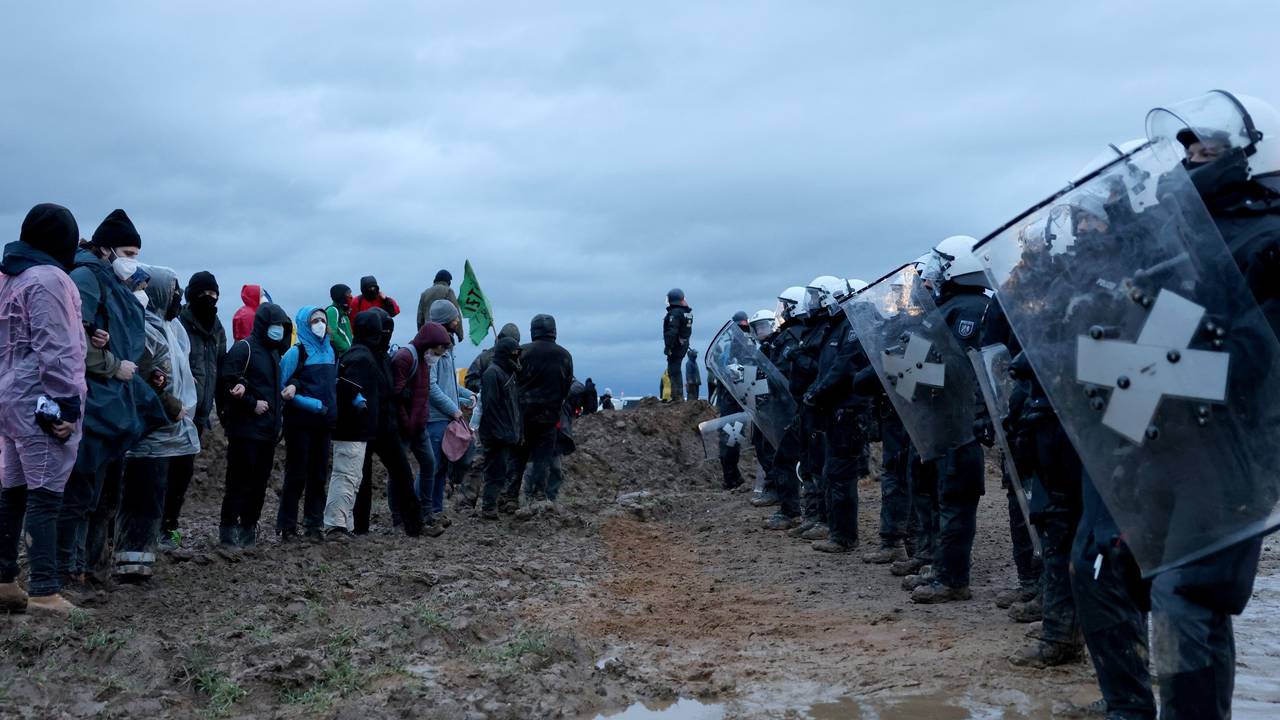 Polizisten und Demonstranten stehen sich bei der Demonstration von Klimaaktivisten am Rande des Braunkohletagebaus bei Lützerath gegenüber.