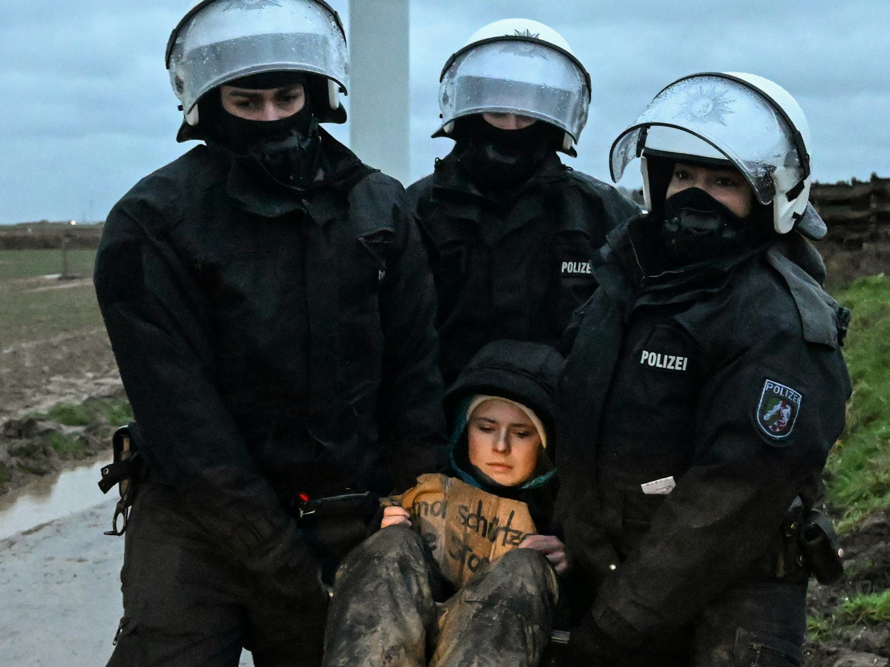 Umweltaktivistin Luisa Neubauer wird von Polizisten während einer Sitzblockade weggetragen. Die Demonstranten hatten versucht am zweiten Tag der Räumung durch die Polizei über Äcker zum besetzten Braunkohleort Lützerath zu gelangen und wurden von der Polizei gestoppt.