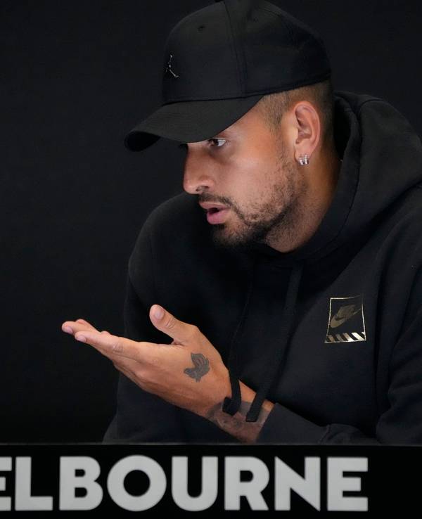 Nick Kyrgios spricht mit Baseball-Kappe bei einer pressekonferenz.