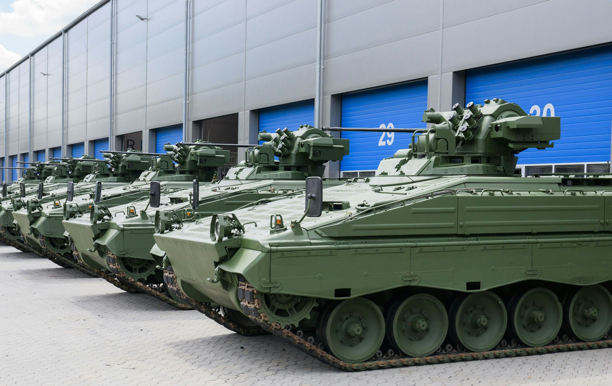 Wieder aufbereitete Marder-Schützenpanzer stehen bei einer Führung durch das Rheinmetall-Werk anlässlich der Sommerreise des niedersächsischen Wirtschaftsministers vor einer Halle.