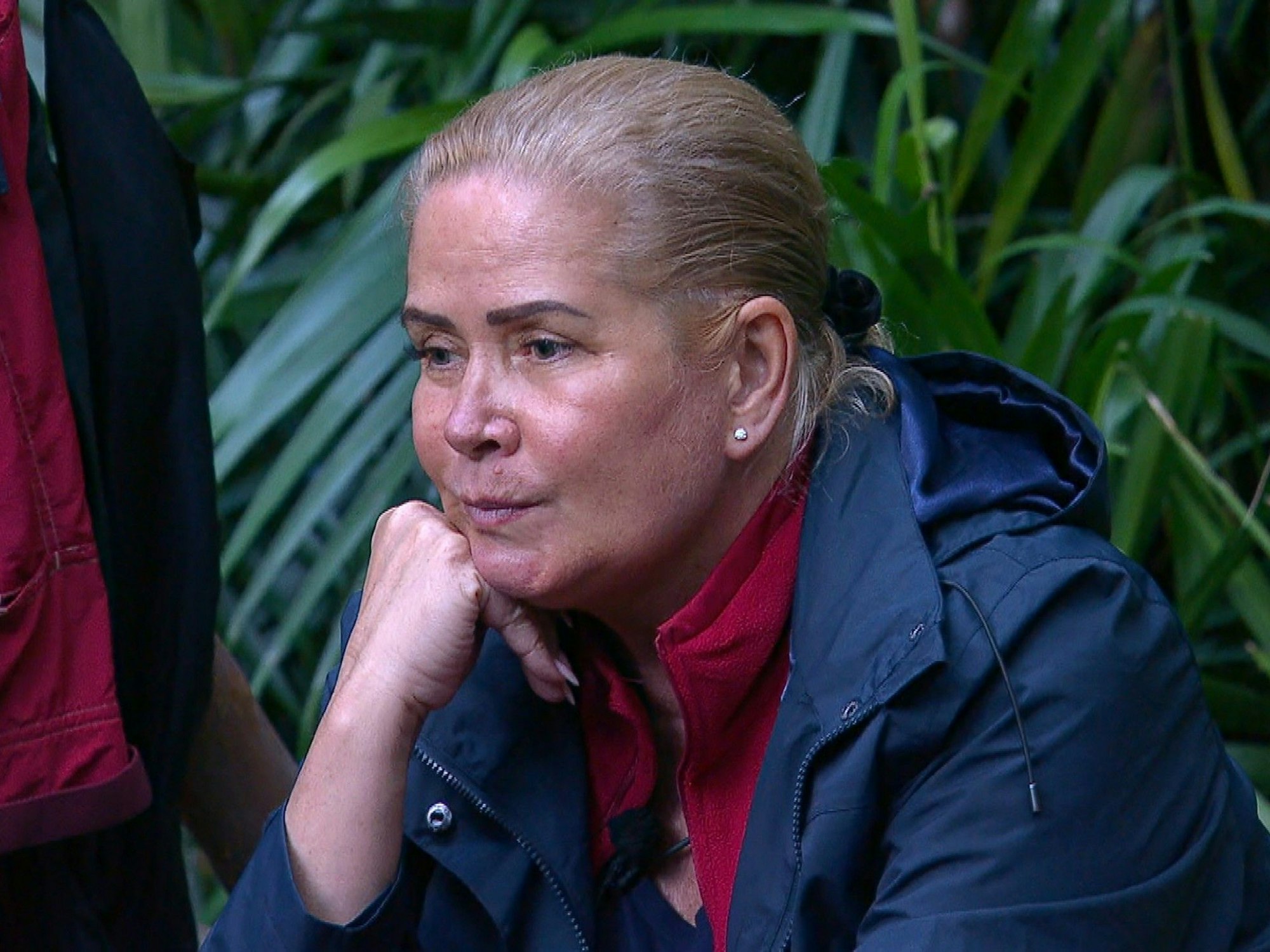 Claudia Effenberg sitzt im Dschungelcamp am Lagerfeuer.