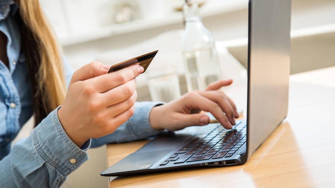 Eine Frau, hier im Oktober 202 in Wittenberge, tippt die Nummer ihrer Kreditkarte in ein Laptop. Ein großer Online-Händler führt noch in diesem Jahr Neuerungen bei Bestellungen auf dessen Website ein.