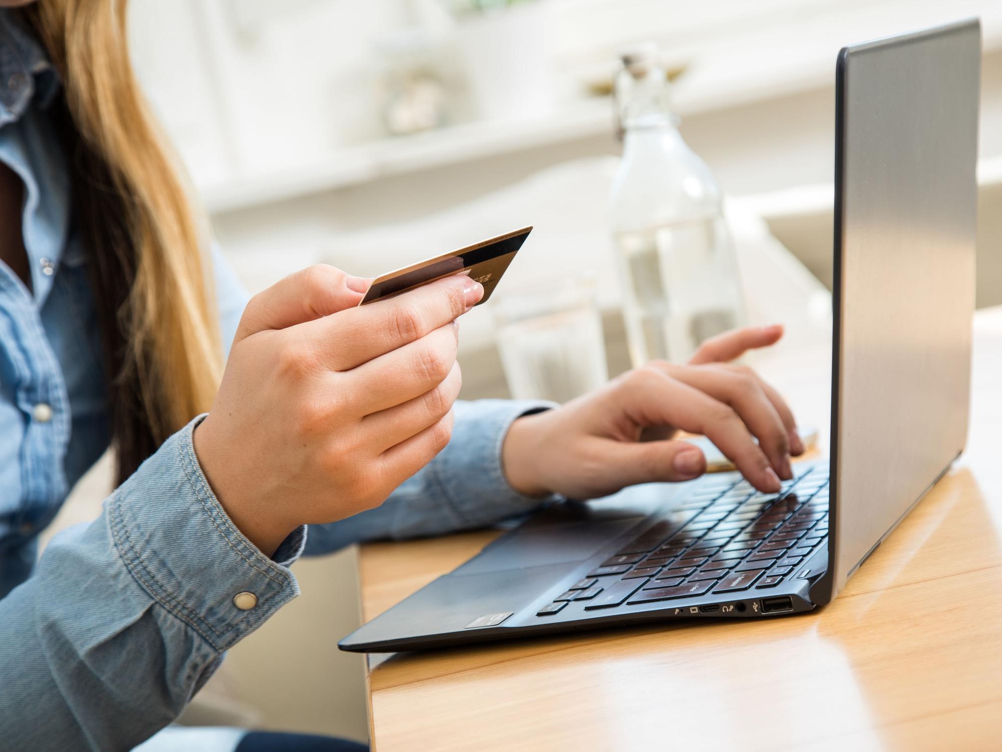 Eine Frau, hier im Oktober 202 in Wittenberge, tippt die Nummer ihrer Kreditkarte in ein Laptop. Ein großer Online-Händler führt noch in diesem Jahr Neuerungen bei Bestellungen auf dessen Website ein.