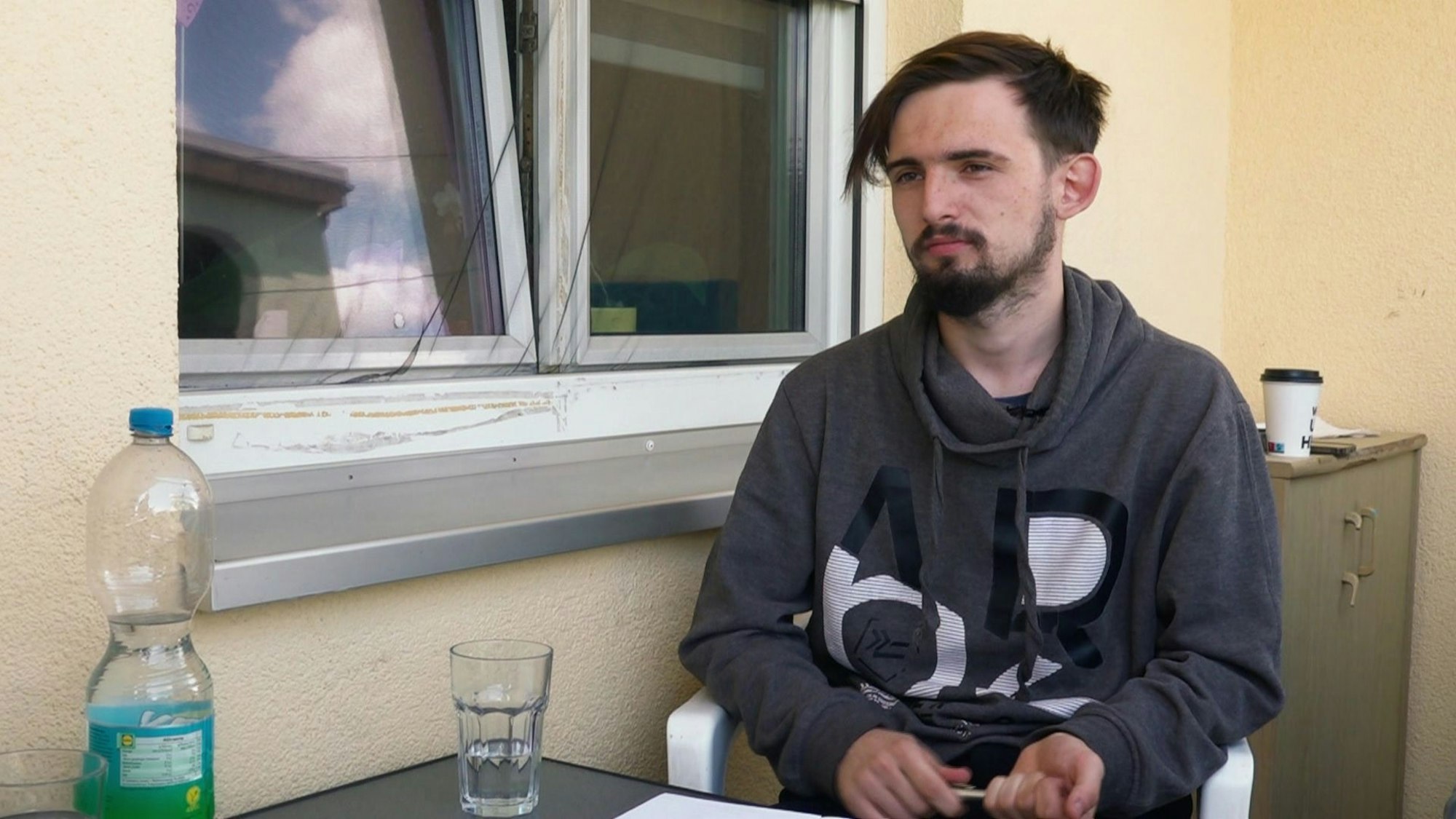 Jerrick unterhält sich mit seiner Mutter Ella auf der Terrasse.