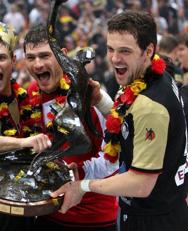 Handball-WM, Finale im Jahr 2007: Deutschland besiegte Polen in der Lanxess-Arena. Trainer Heiner Brand (l-r) hält den WM-Pokal zusammen mit seinen Spielern Michael Kraus, Torwart Henning Fritz und Kapitän Markus Bauer.