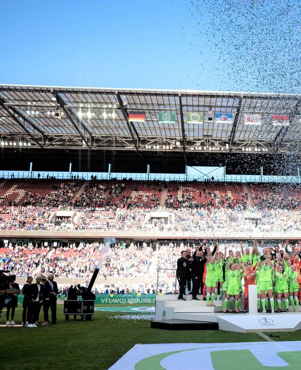 Die Spielerinnen von VfL Wolfsburg jubeln im Rhein-Energie-Stadion bei der Siegerehrung zum DFB-Pokal.