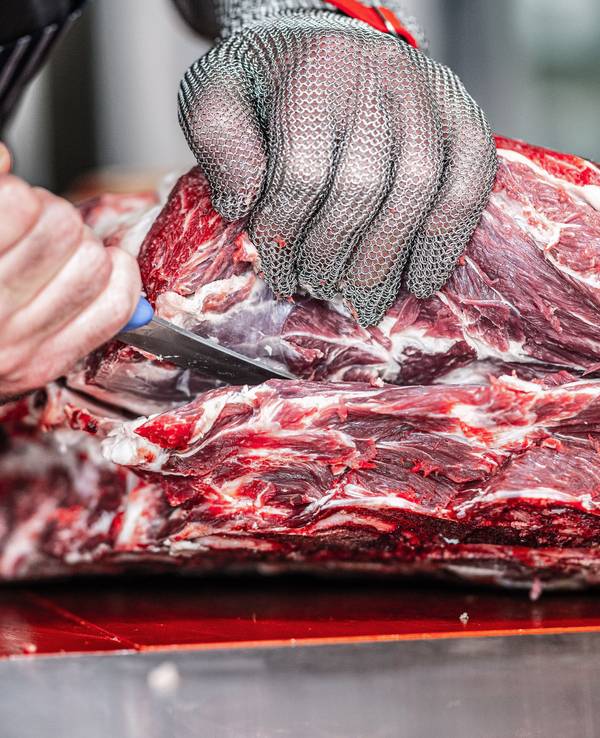 Unser Foto zeigt einen Metzger beim Zerlegen von Fleisch.