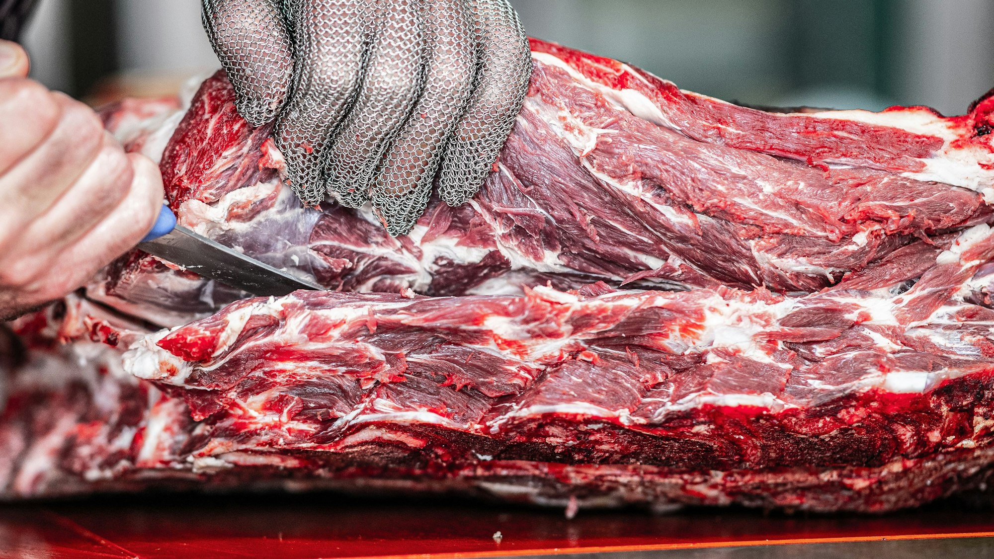 Unser Foto zeigt einen Metzger beim Zerlegen von Fleisch.