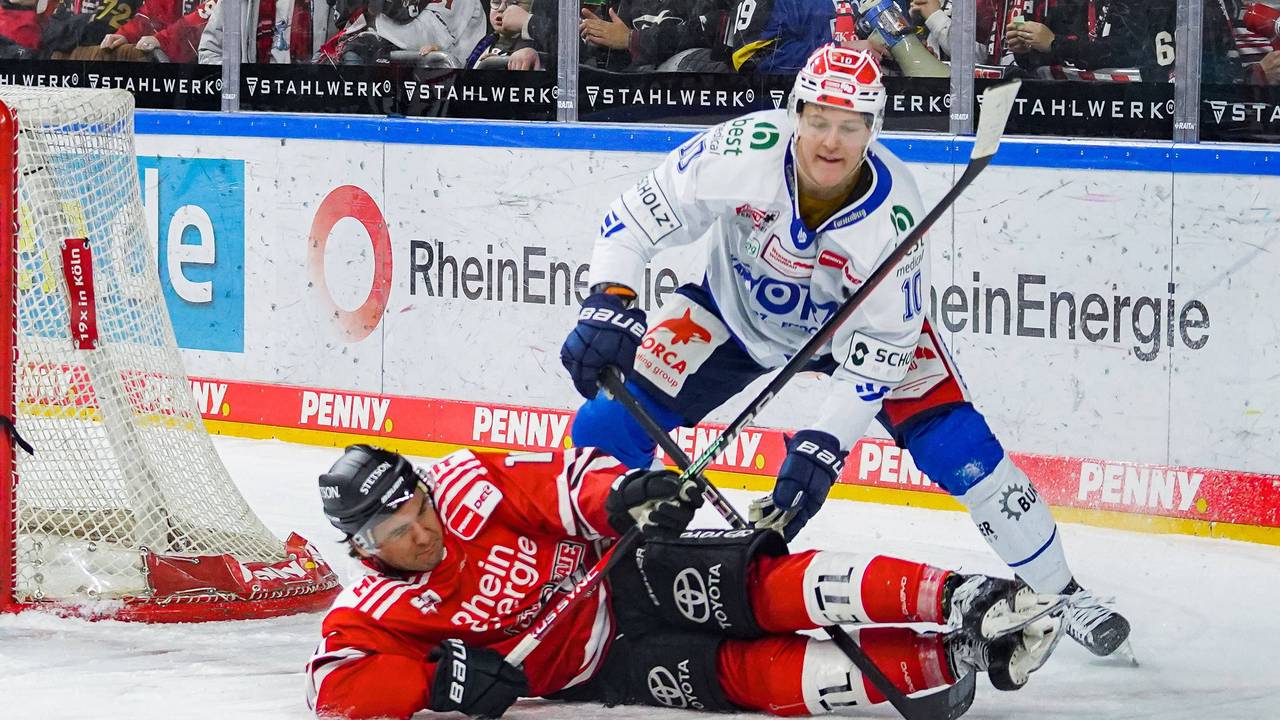 Jon Matsumoto liegt am Boden und kämpft mit Schwenningens Peter Stpornberger um den Puck.