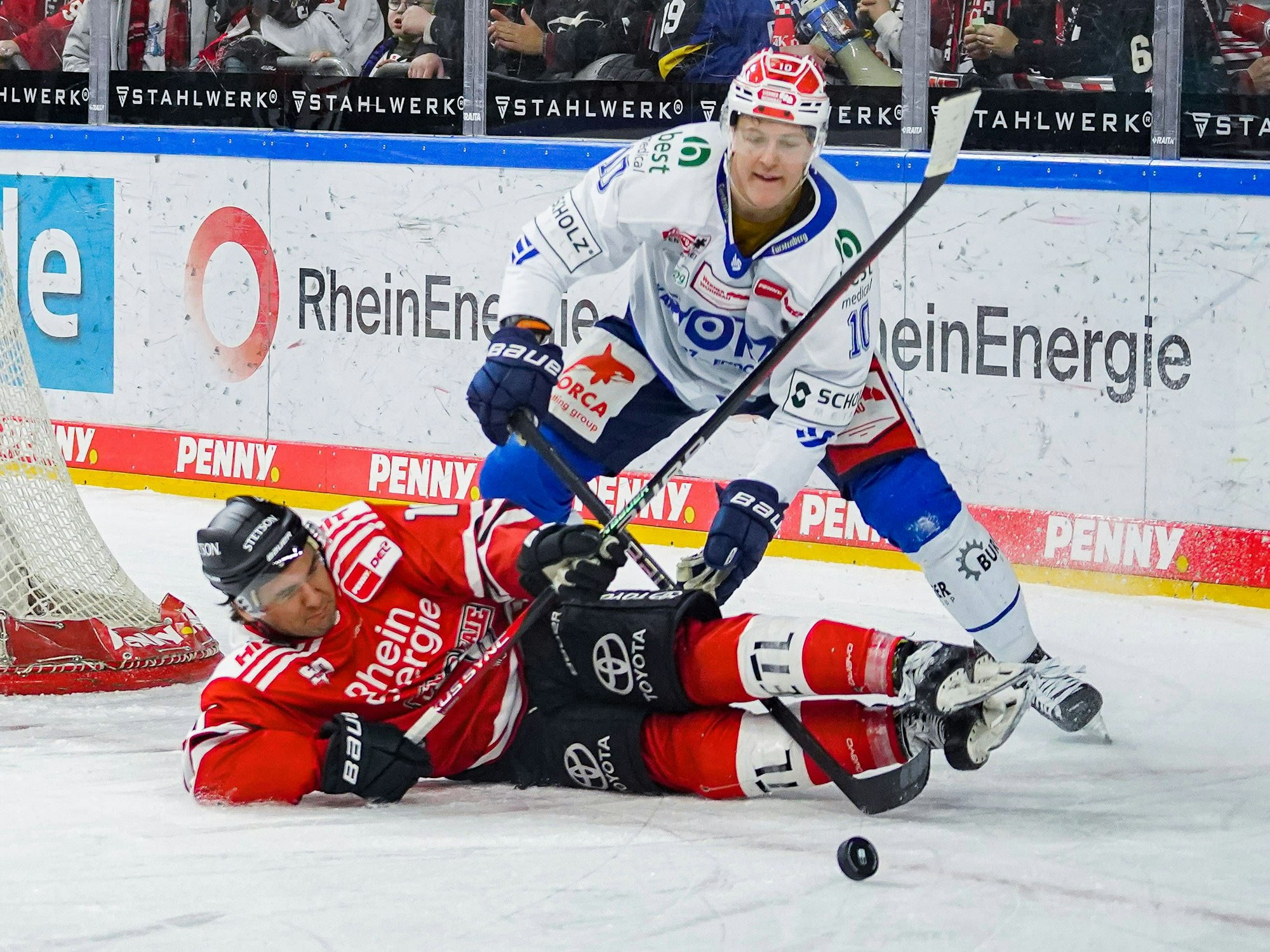 Jon Matsumoto liegt am Boden und kämpft mit Schwenningens Peter Stpornberger um den Puck.