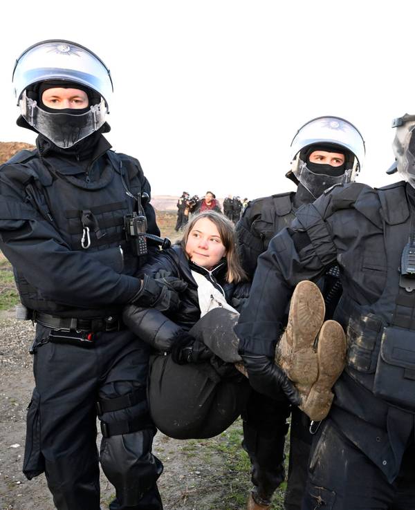 Polizisten tragen die schwedische Klimaaktivistin Greta Thunberg (M) aus einer Gruppe von Demonstranten und Aktivisten heraus und vom Rand des Braunkohlentagebaus Garzweiler II weg.