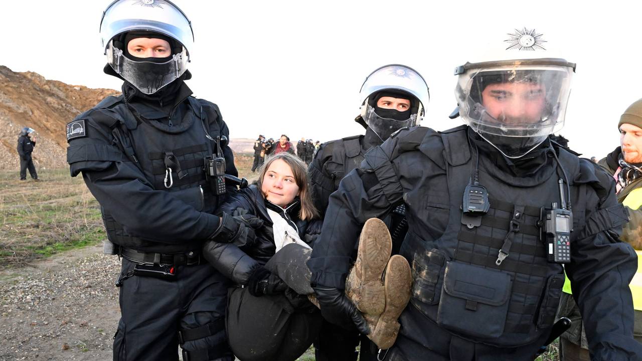 Polizisten tragen die schwedische Klimaaktivistin Greta Thunberg (M) aus einer Gruppe von Demonstranten und Aktivisten heraus und vom Rand des Braunkohlentagebaus Garzweiler II weg.