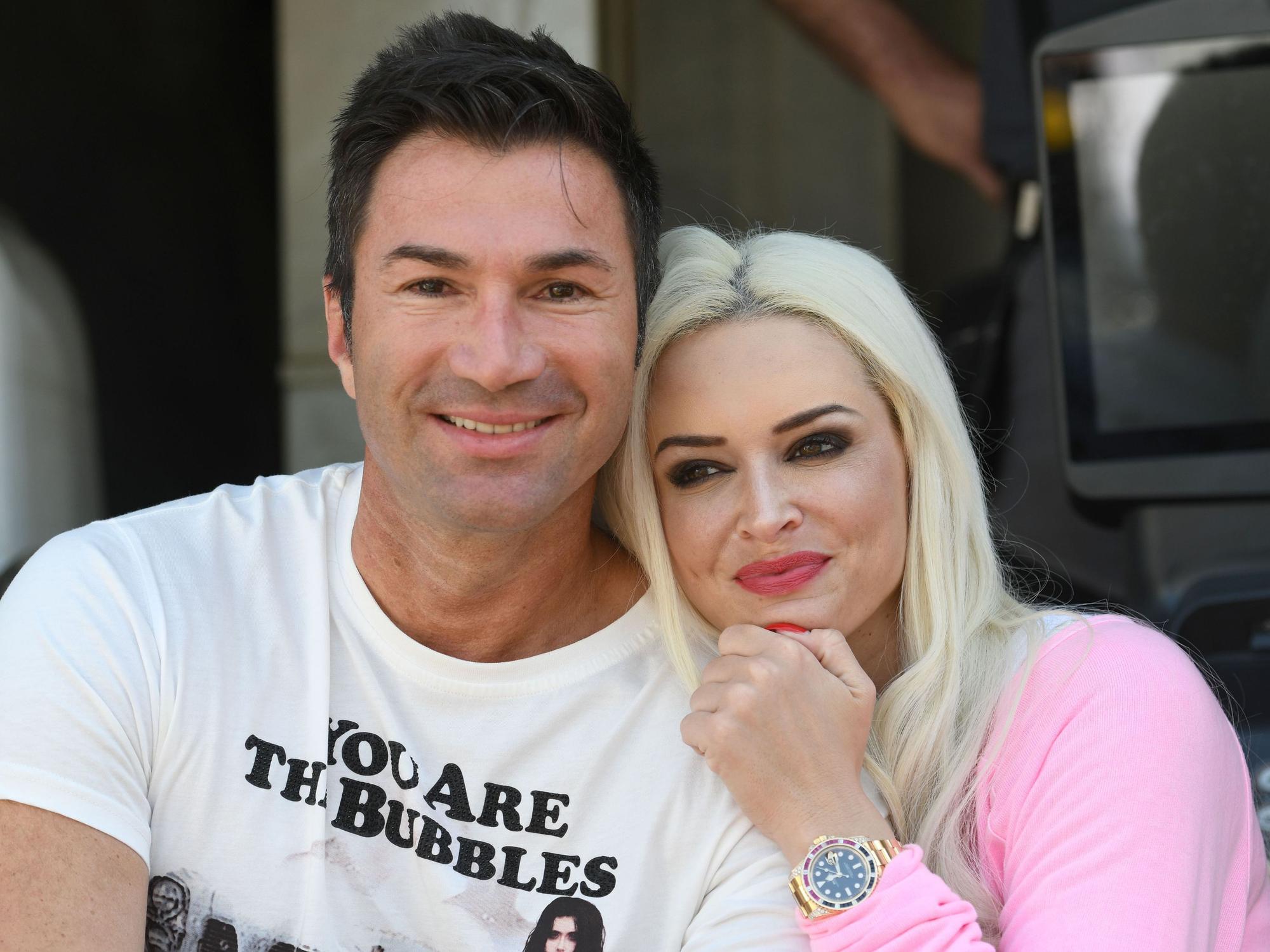 Das Model Daniela Katzenberger und ihr Mann, der Sänger Lucas Cordalis sitzen vor einem Container mit Umzugskartons und Möbeln.