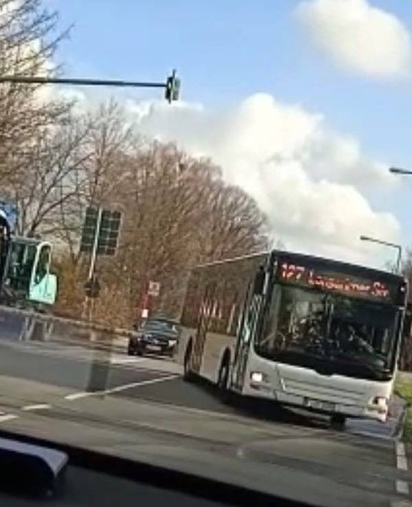 Ein Bus fährt am Bahnübergang Butzweilerstraße an der geschlossenen Halbschranke herum.