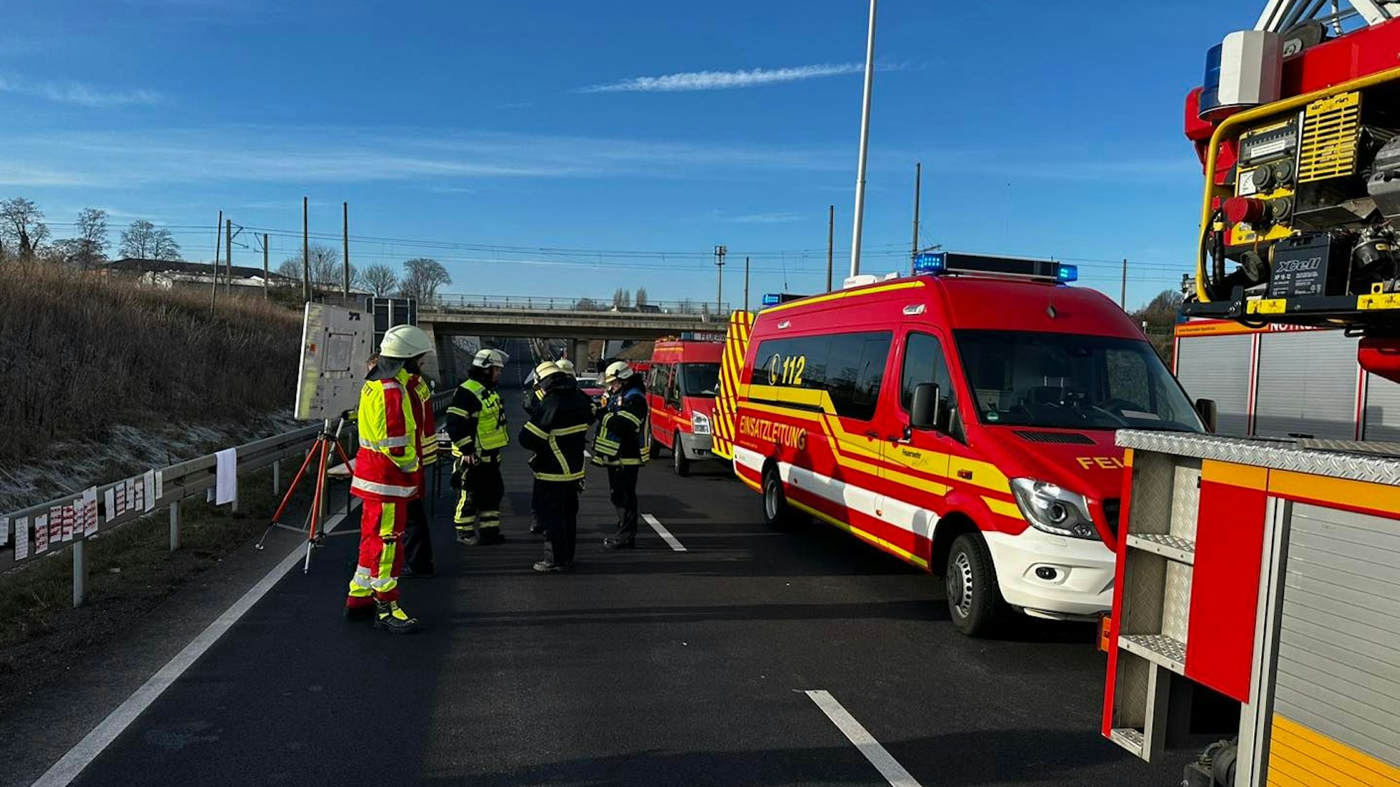 Einsatzfahrzeuge der Feuerwehr stehen auf der Hürther Umgehungsstraße, daneben mehrere Einsatzkräfte.