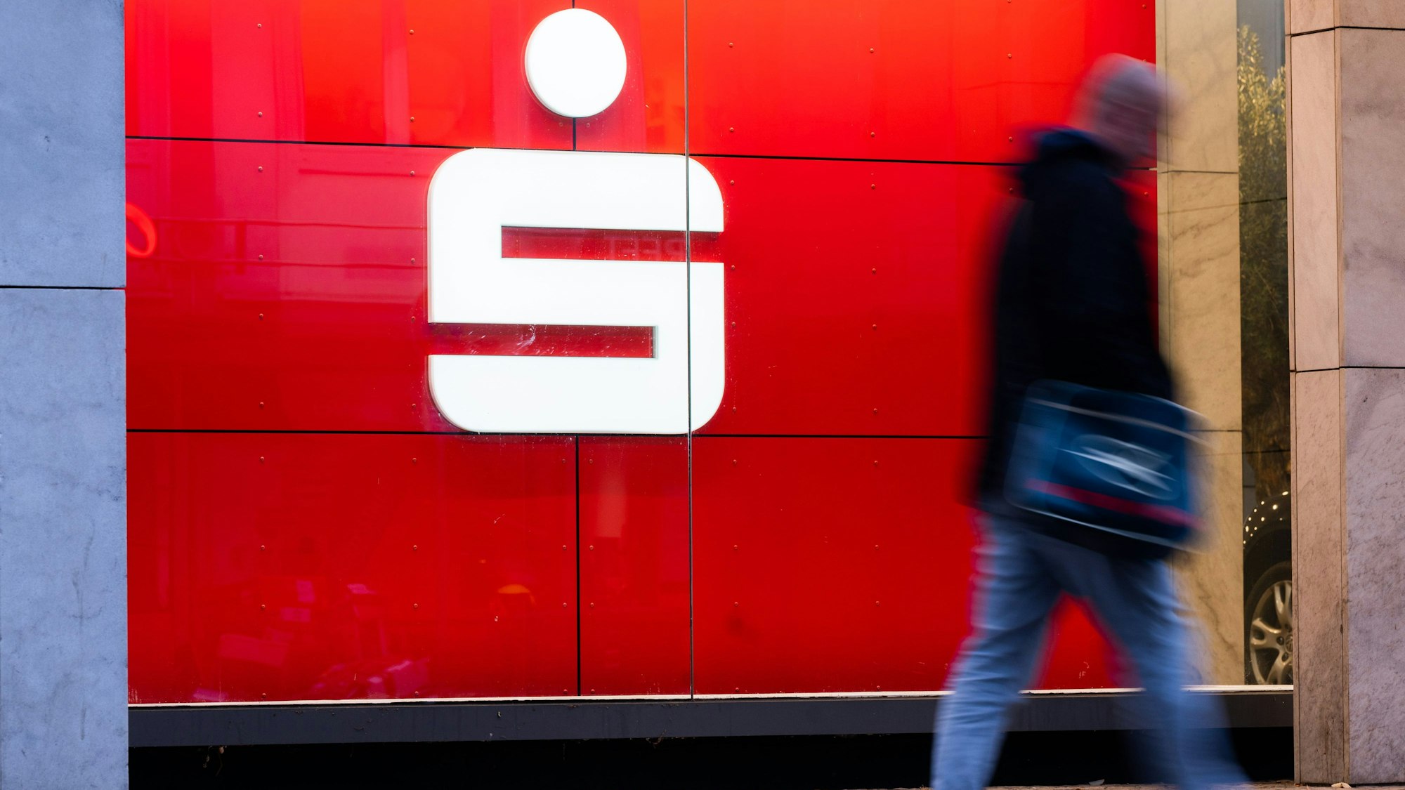Passanten laufen an einer Filiale der Sparkasse vorbei.