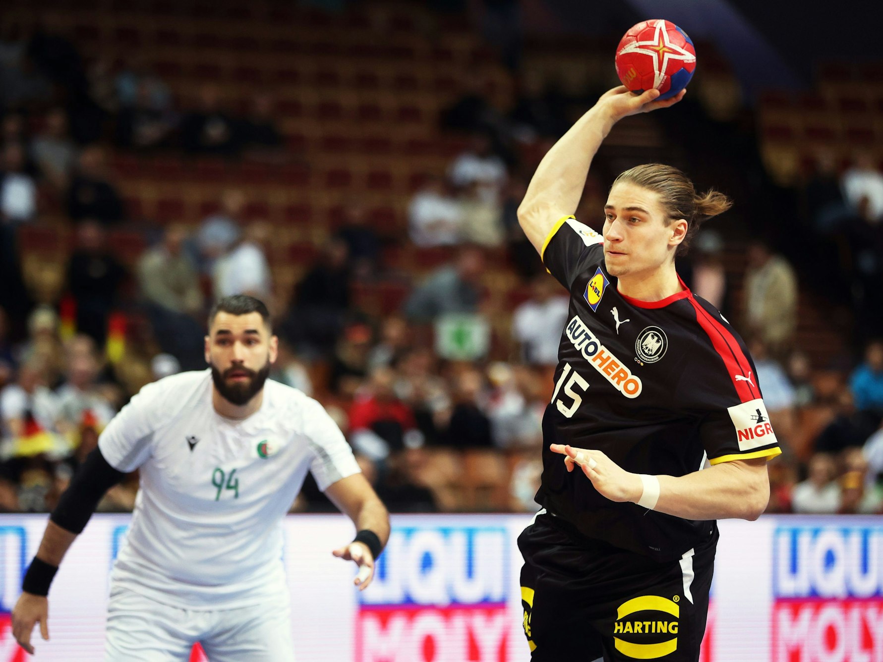 Juri Knorr (r) aus Deutschland wirft den Ball neben Bastien Khermouche (l) aus Algerien.