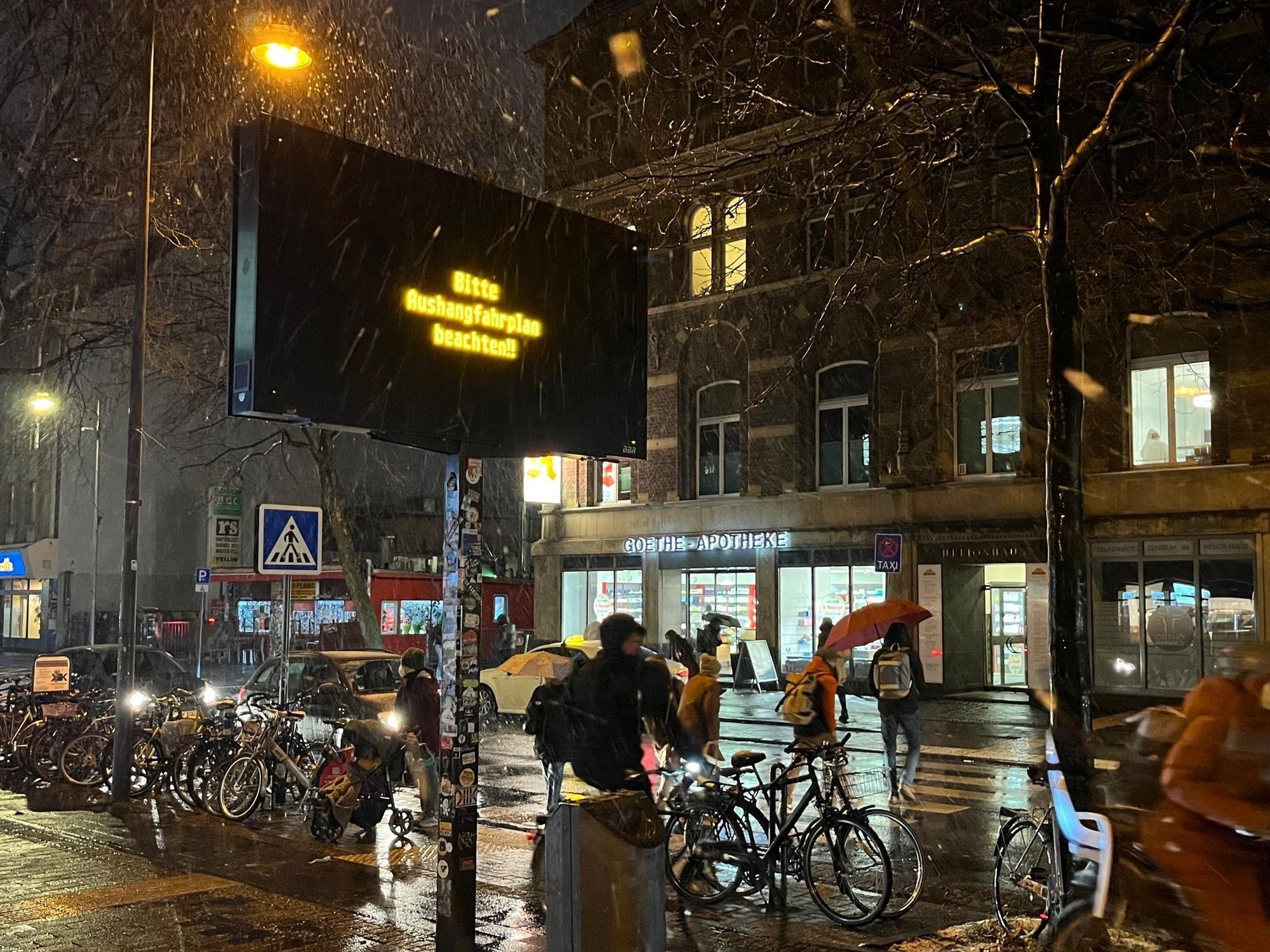 Eine KVB-Anzeigetafel zeigt den Schriftzug: „Bitte Aushangfahrplan beachten!“