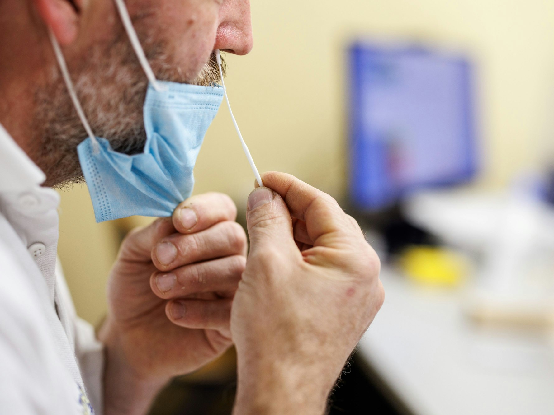 Ein Mitarbeiter führt im Büro des Produktionsleiters in einem Produktionsgebäude der Bäckerei- und Konditoreikette Traublinger ein Stäbchen für einen Corona-Schnelltest in seine Nase ein. +++ dpa-Bildfunk +++