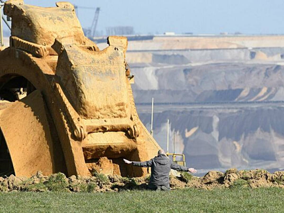 Das „NRW-Pressefoto 2022“ von Barbara Schnell zeigt einen Aktivisten sitzend vor einem Braunkohlebagger.