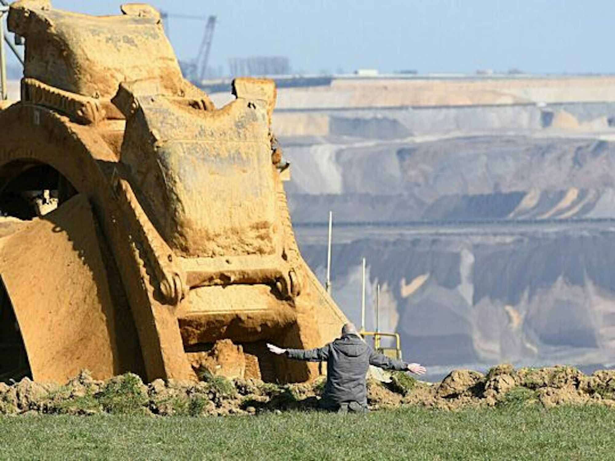 Das „NRW-Pressefoto 2022“ von Barbara Schnell zeigt einen Aktivisten sitzend vor einem Braunkohlebagger.