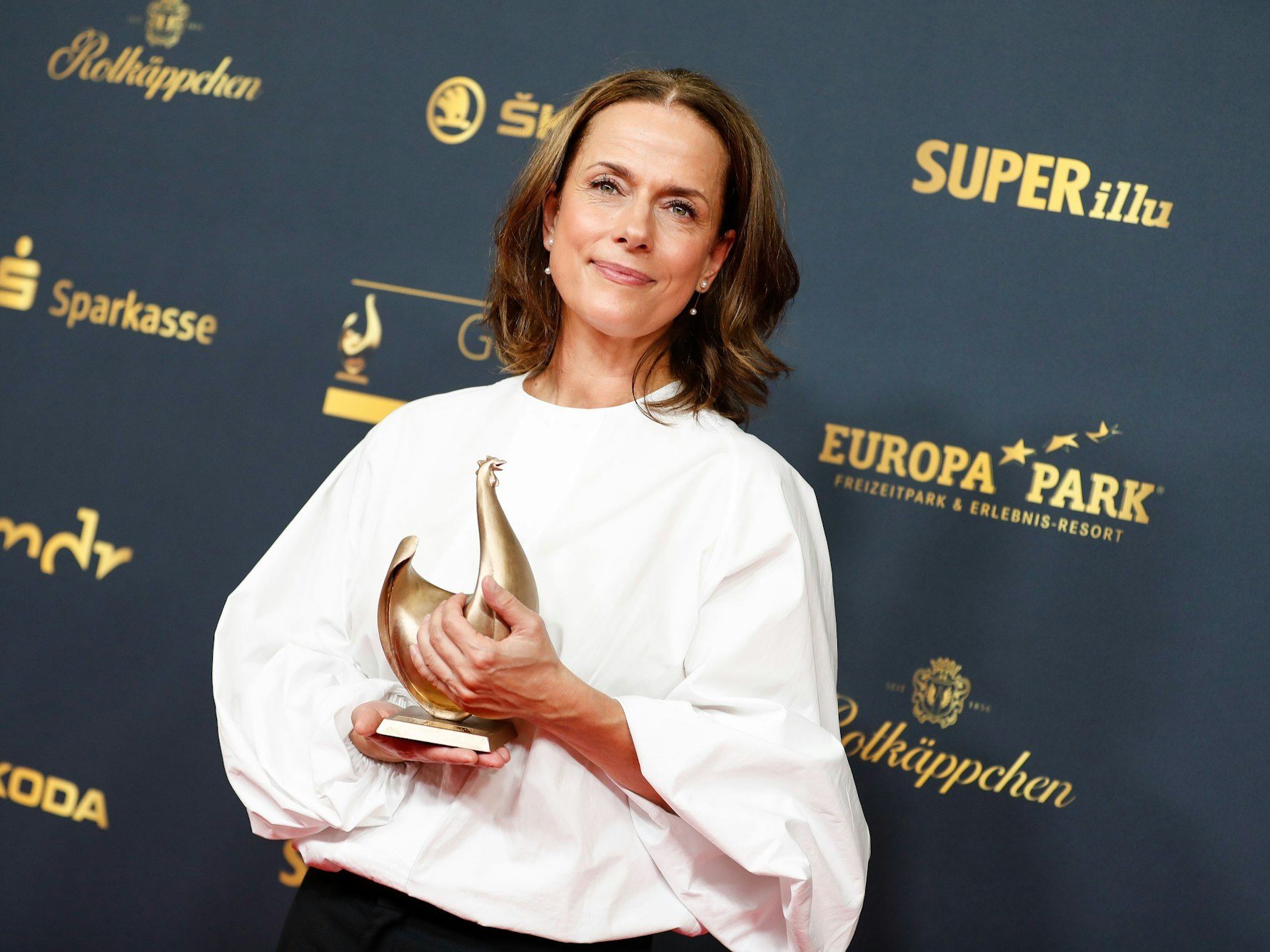 Claudia Michelsen posiert mit dem Preis „Goldene Henne“ in der Kongresshalle Leipzig.