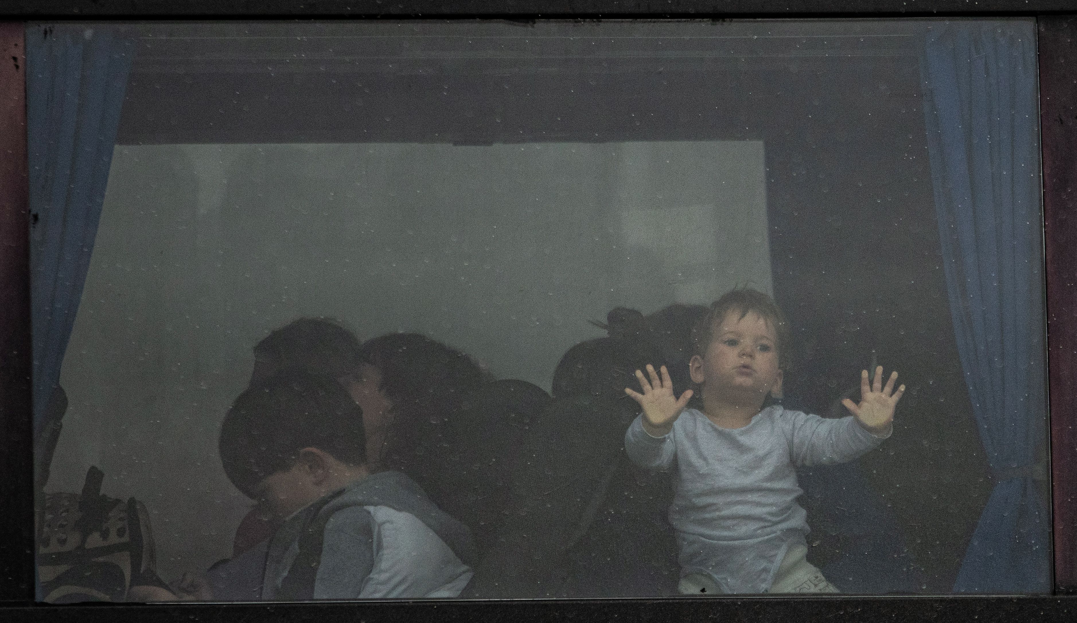 Ein Kind steht im Fenster eines Busses, der am Grenzübergang Porubne in der Westukraine auf die Überfahrt nach Rumänien wartet.