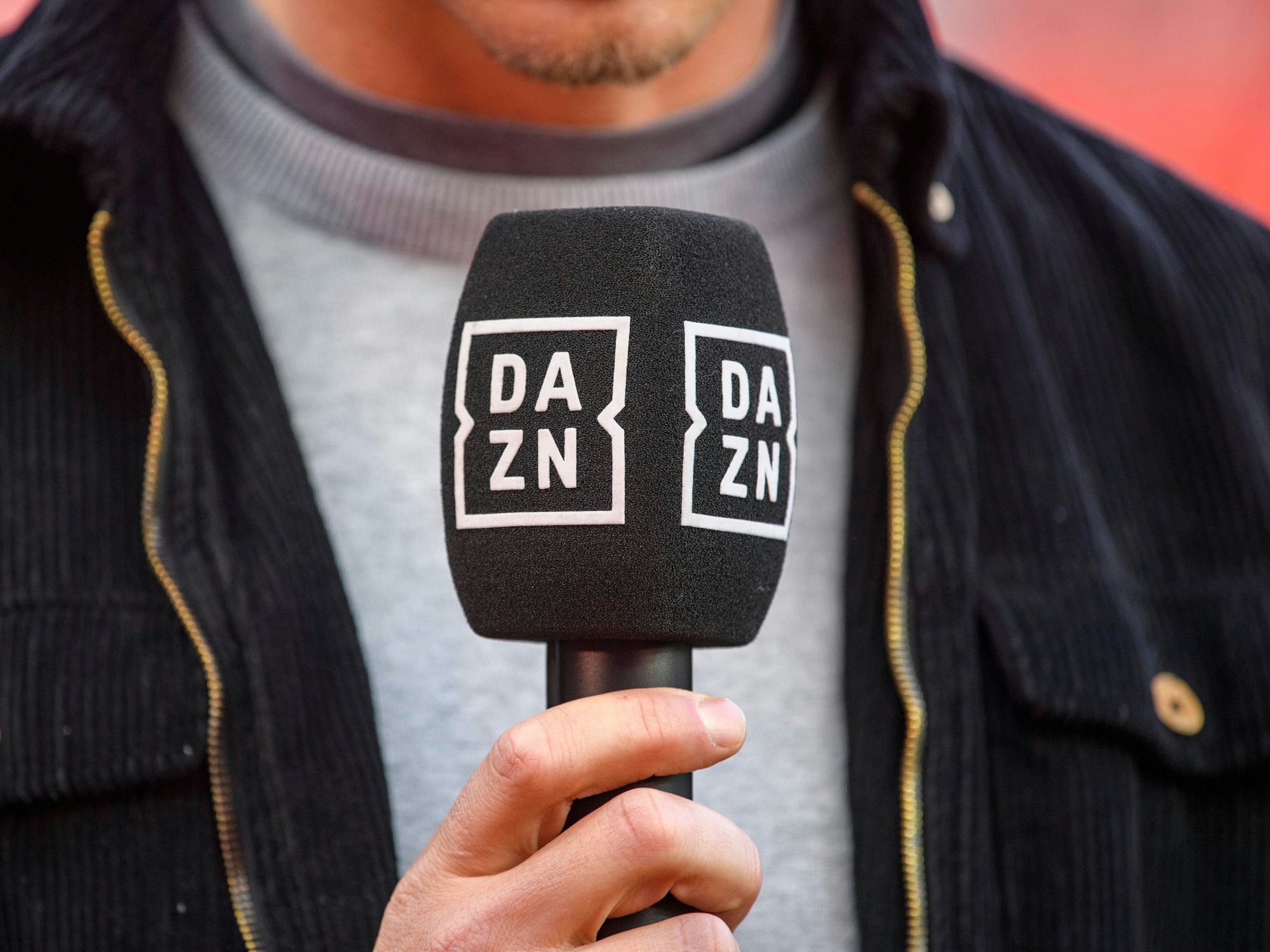 Jemand spricht in ein Mikrofon von DAZN.