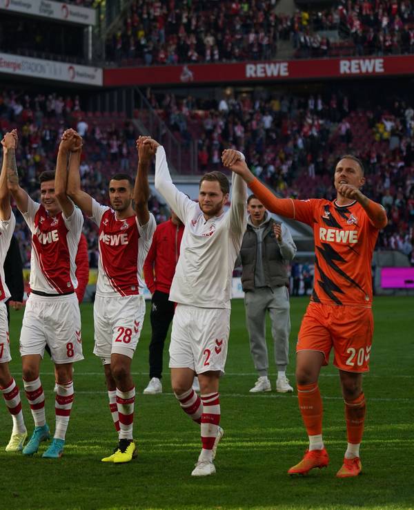 Die Spieler des 1. FC Köln jubeln vor der Südkurve.