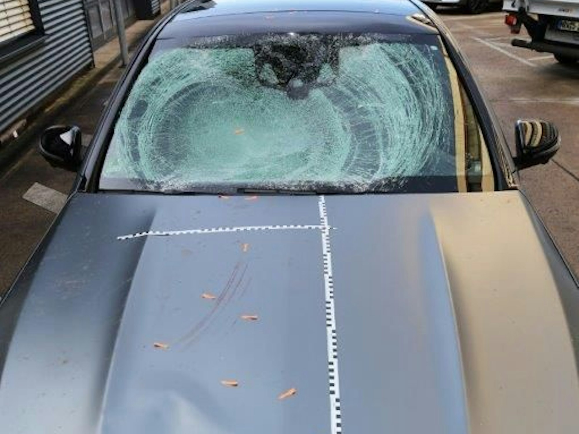 Die Windschutzscheibe des Unfall-Mercedes ist völlig zersplittert, auf der Motorhaube sind Markierungen der Spurensicherung.