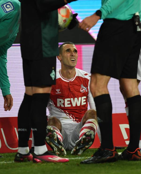 Ellyes Skhiri sitzt beim 1. FC Köln verletzt auf dem Rasen.