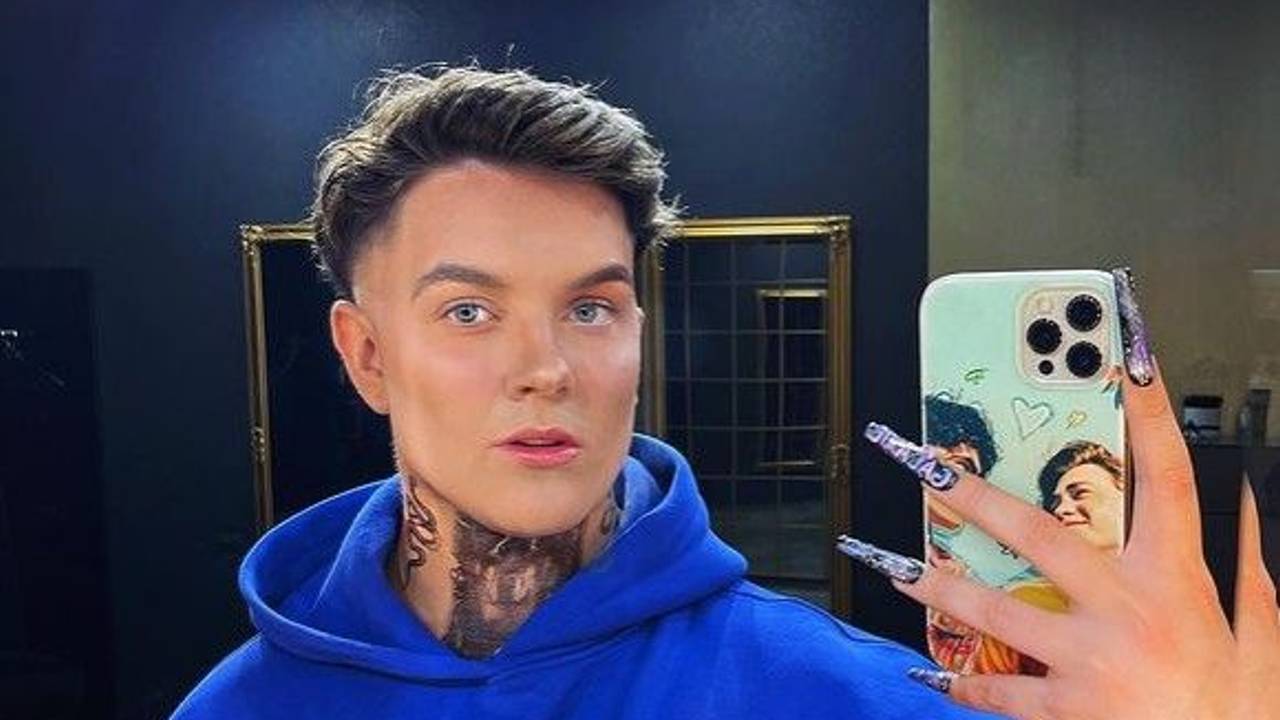 Influencer Twenty4Tim lächelt in einem blauen Pullover in die Handy-Kamera.