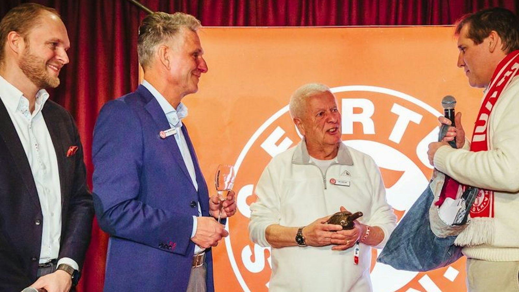 Fortuna-Urgestein Paul Sennelaub erhielt die "Bronzene Stadionwurst" für sein Engagement bei Fortuna Köln. Mit auf dem Foto: Künstler Cornel Wachter (r.) sowie Fortuna-Präsident Hanns-Jörg Westendorf und Markus Römer; Senior Marketing Manager für das Musical "Moulin Rouge".