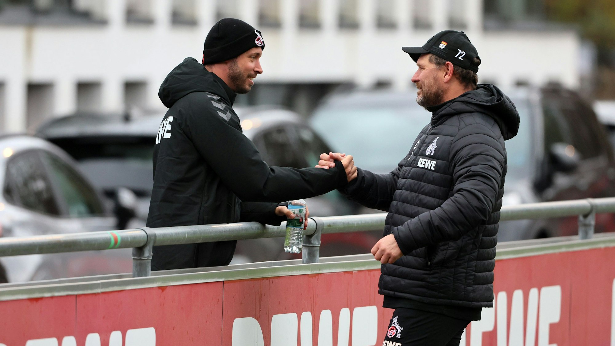 Mark Uth und Steffen Baumgart geben sich beim Training des 1. FC Köln die Hand.