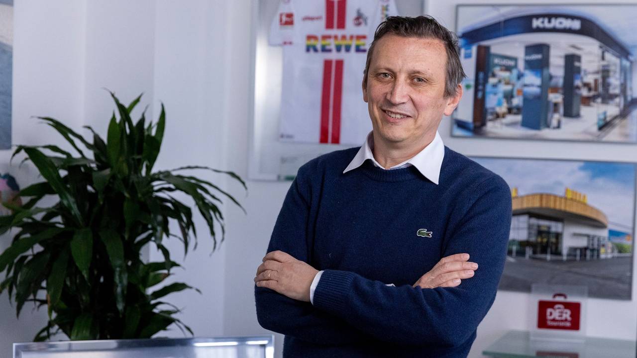 Ein Mann steht mit verschränkten Armen in einem Büro.
