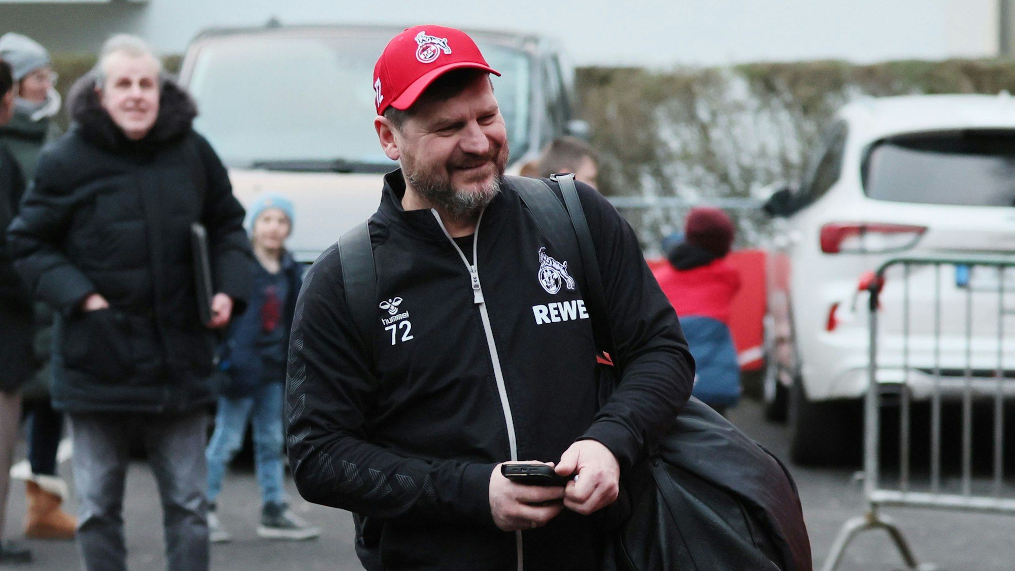 Steffen Baumgart läuft am Geißbockheim grinsend zum Mannschaftsbus.