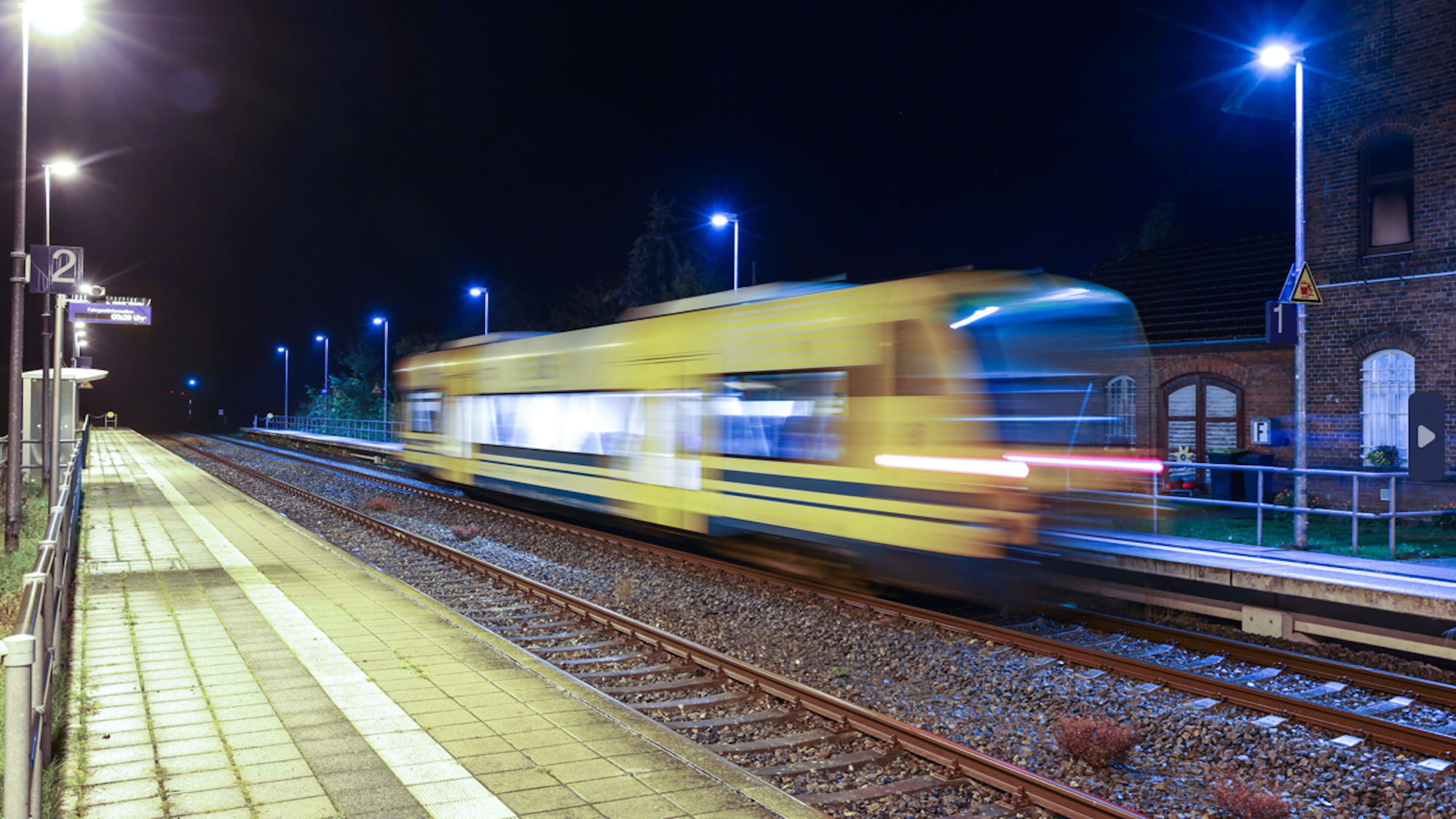 Eine Regionalbahn fährt im Dunkeln in einem Bahnhof ein.