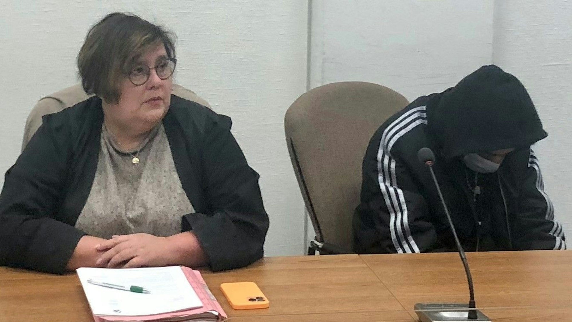 Der Angeklagte sitzt in sich zusammengesunken neben seiner Anwältin Karin Bölter.