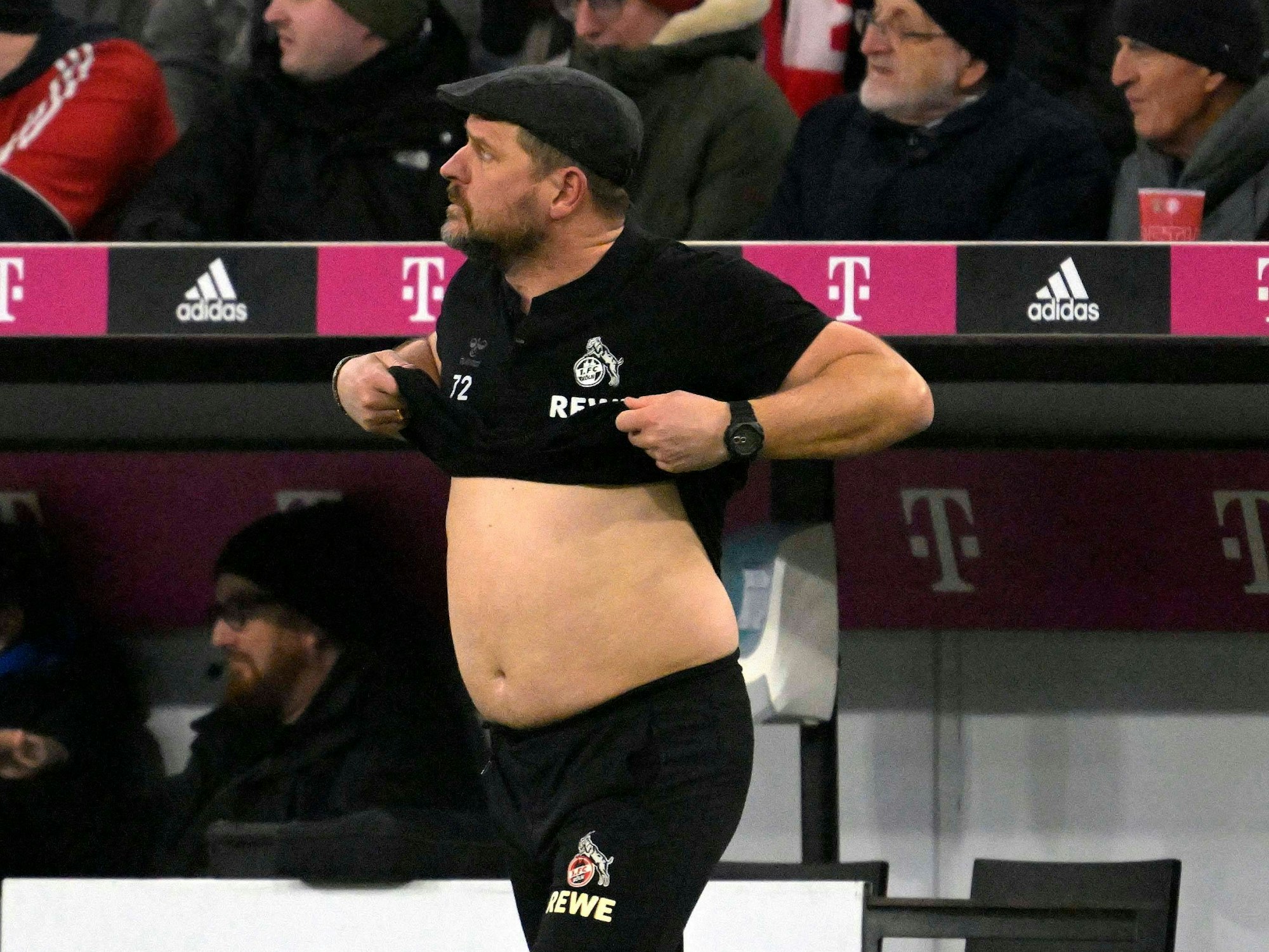 Steffen Baumgart zieht sein T-Shirt hoch.