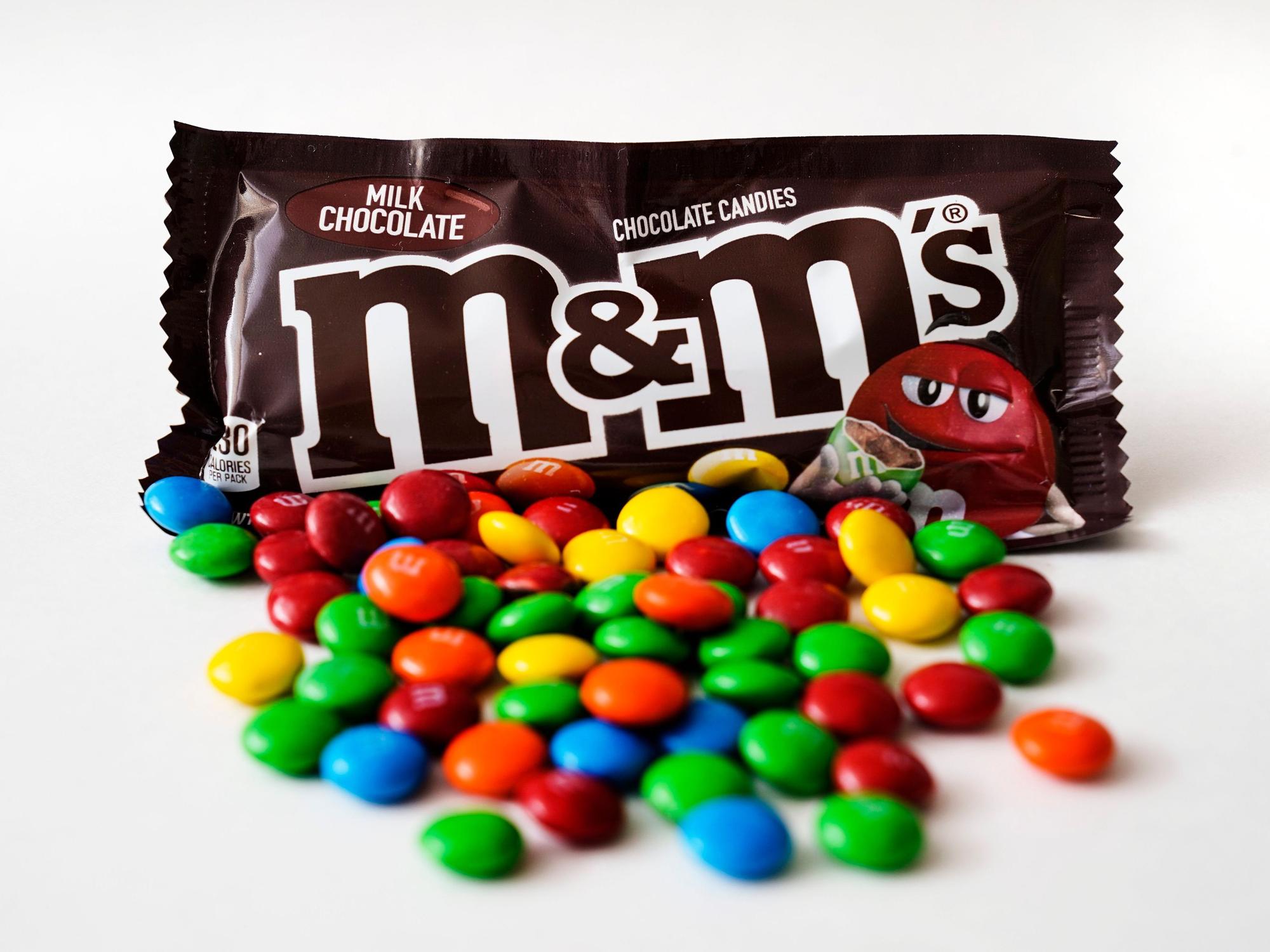 M&M's liegen vor einer Packung der Schokolinsen.