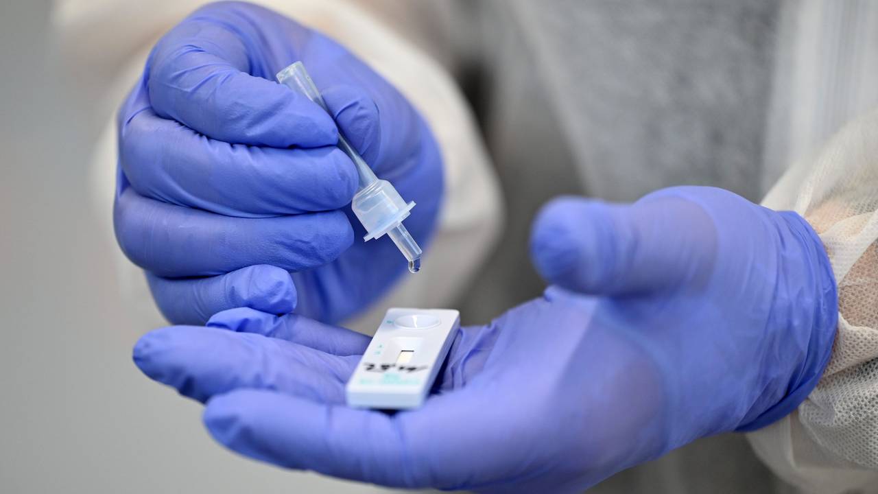 Ein Helfer verarbeitet eine Probe für einen Corona-Schnelltest. Ab dem 1. Februar müssen Corona-Infizierte in NRW nicht mehr in häusliche Isolation.