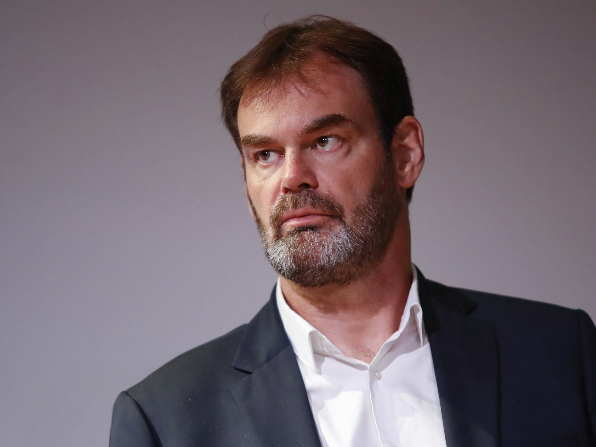 Bruno Martini schaut ernst während einer Handball-Konferenz.