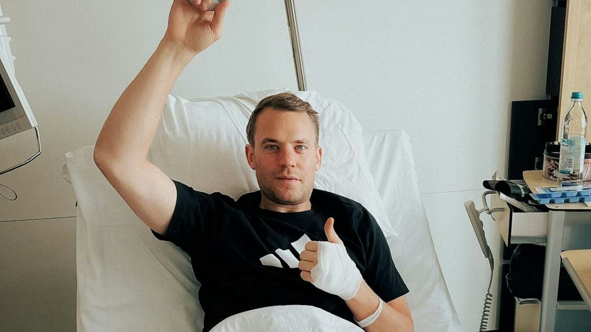 Manuel Neuer gibt einen Daumen nach oben aus dem Krankenhausbett.