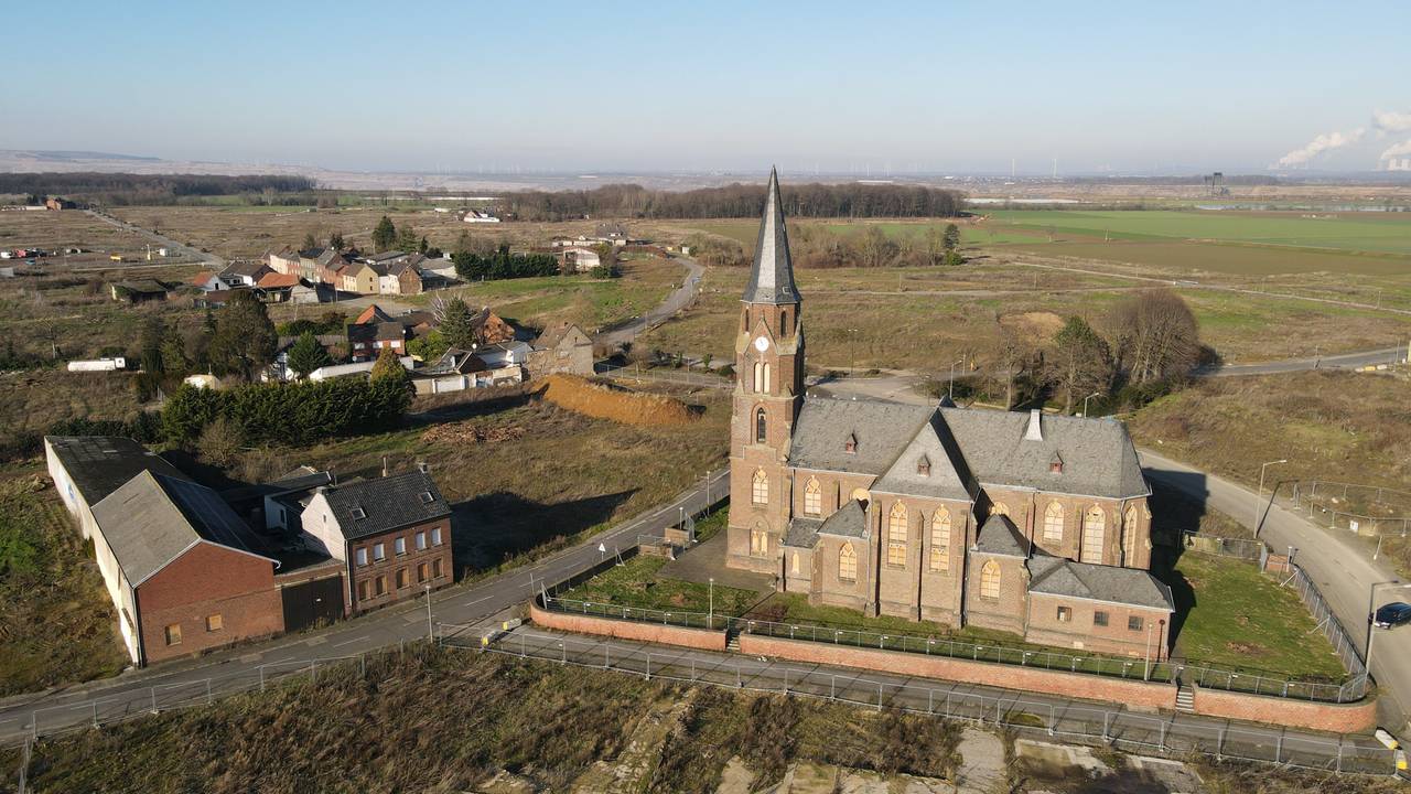 Wie ein Mahnmal ragt die entweihte Kirche St. Albanus und Leonhardus in Manheim-alt in den Himmel. Im Hintergrund naht der Tagebau Hambach.