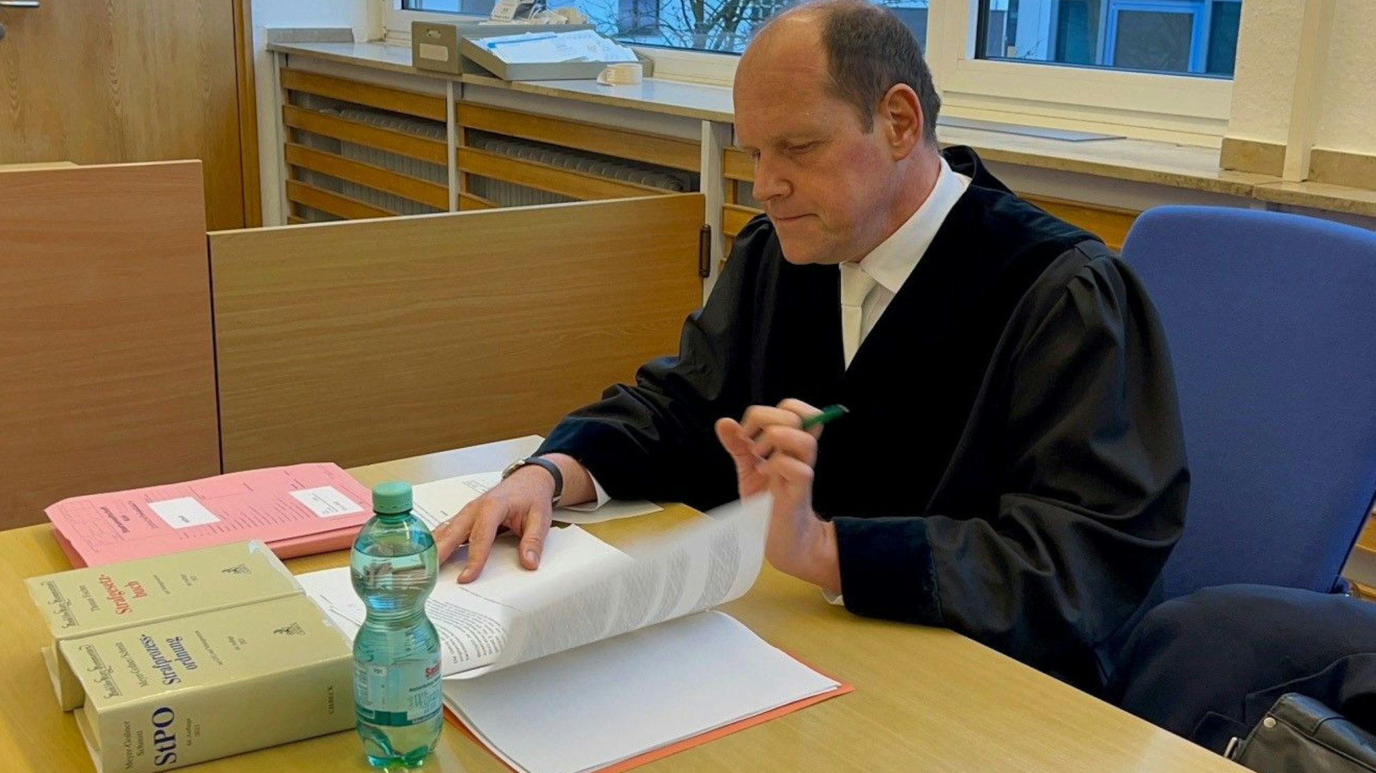 Oberstaatsanwalt Ulf Willuhn blättert in seinen Akten in der Strafsache gegen einen Kölner Hooligan.