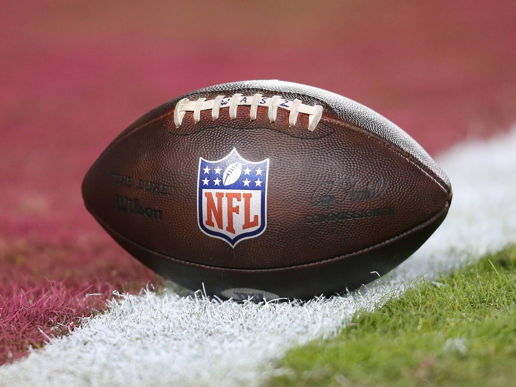 Ein Football liegt auf der Linie eines Spielfeldes.