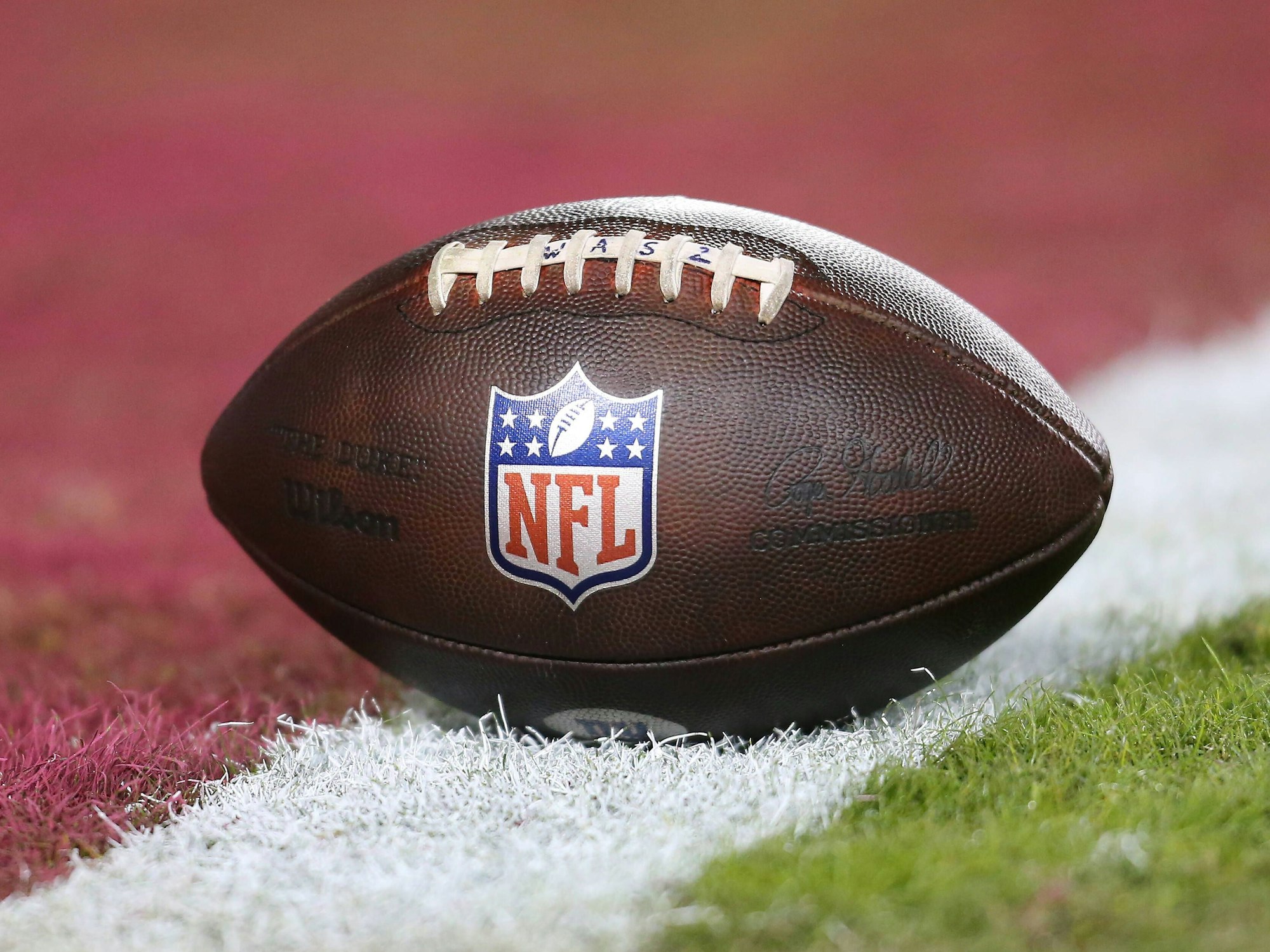 Ein Football liegt auf der Linie eines Spielfeldes.