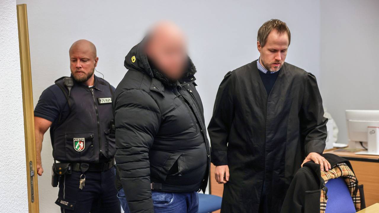 Der Angeklagte (M) steht im Gerichtssaal neben seinem Verteidiger Ingmar Rosentreter (r). Der Mann steh wegen Beteiligung an den Krawallen beim Conference-League-Spiel des 1. FC Köln in Nizza vor Gericht.