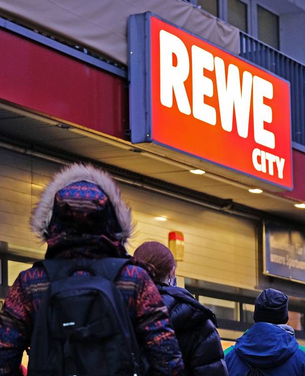 Kundinnen und Kunden vor einem REWE-Supermarkt.