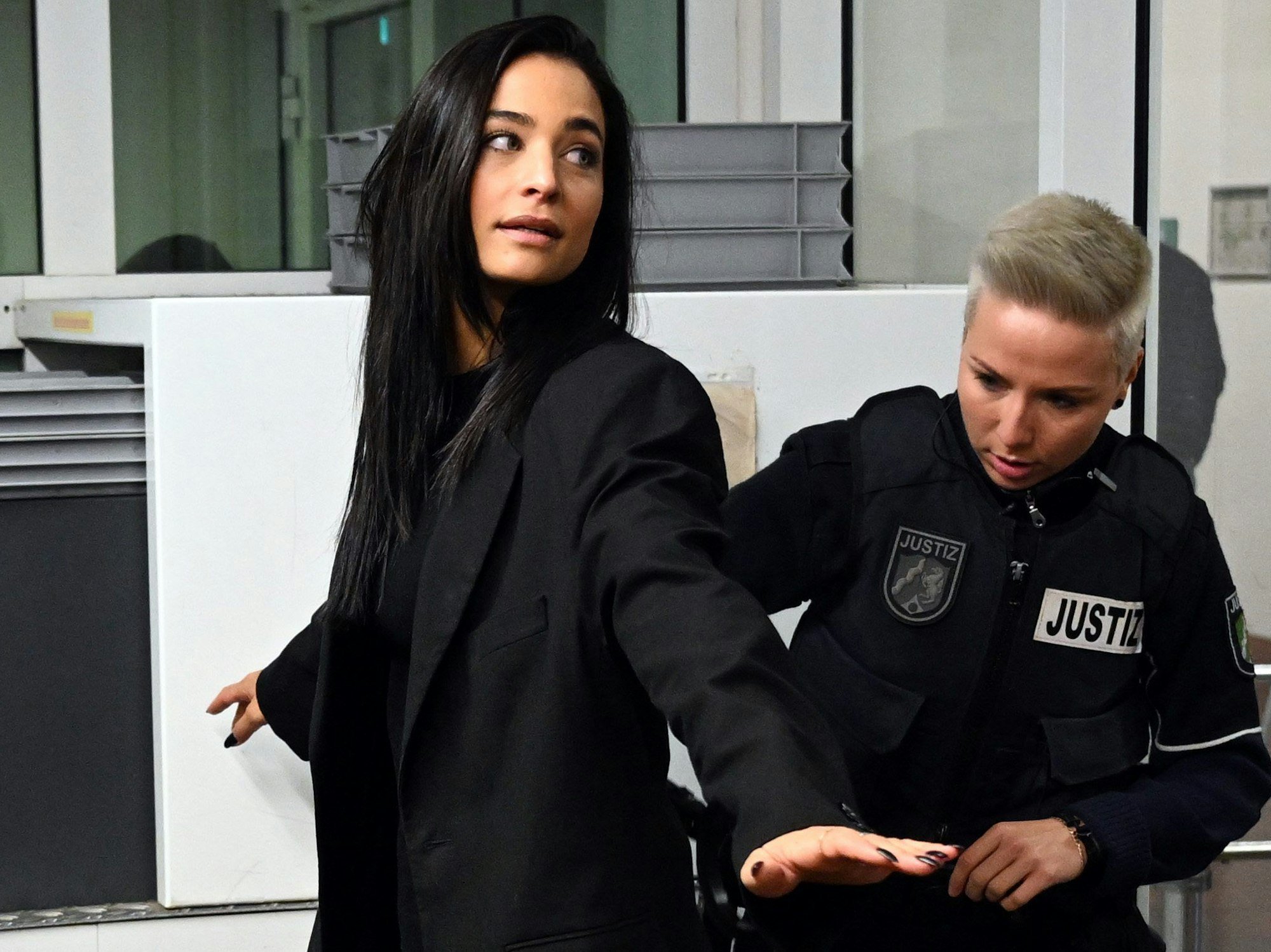 Amira Pocher ist im Amtsgericht Köln bei der Sicherheitskontrolle. Sie wird von einer Justizbeamtin abgetastet.